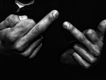 Close-up of hands against black background