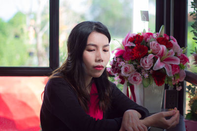 Portrait of beautiful young woman in red flower