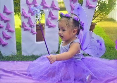 Portrait of a cute girl in purple color playing outdoor  