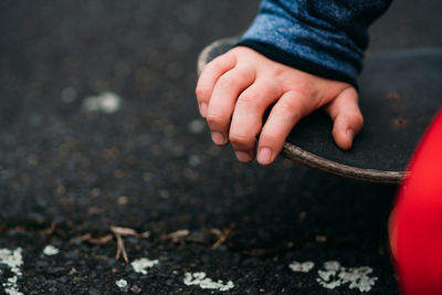 Close-up of boy hand on skateboard