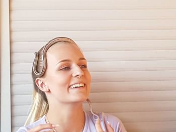 Smiling young woman with snake on head