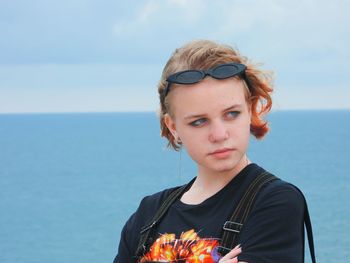 Portrait of young woman against sea against sky