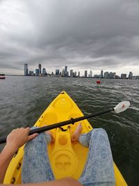 Man and yellow umbrella on sea against sky