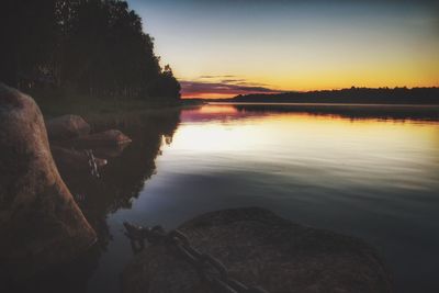 Scenic view of lake against sky at sunset