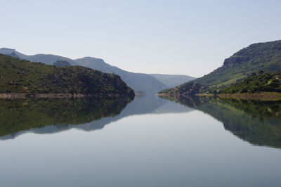 Scenic view of lake and mountains against clear sky