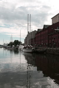 Boats moored in harbor with buildings in background