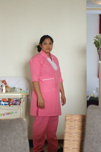 Portrait of a smiling young woman standing at home