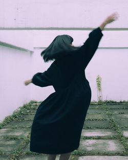 Midsection of woman dancing against wall