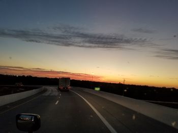 Car on road against sky during sunset