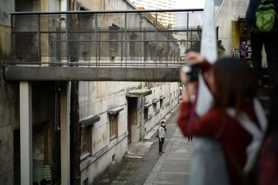 Woman photographing buildings in city