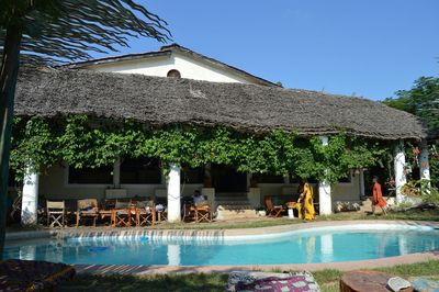 People by swimming pool against clear sky