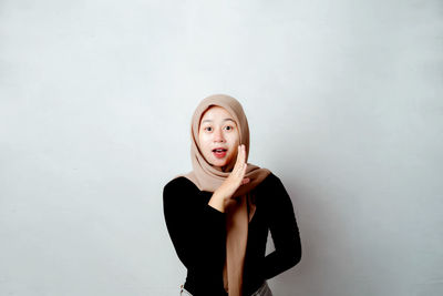 Photo for promotion. portrait of asian hijab woman stretching her arms and showing expression. 