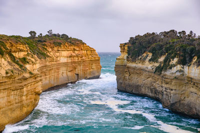 Rock formations by sea against sky