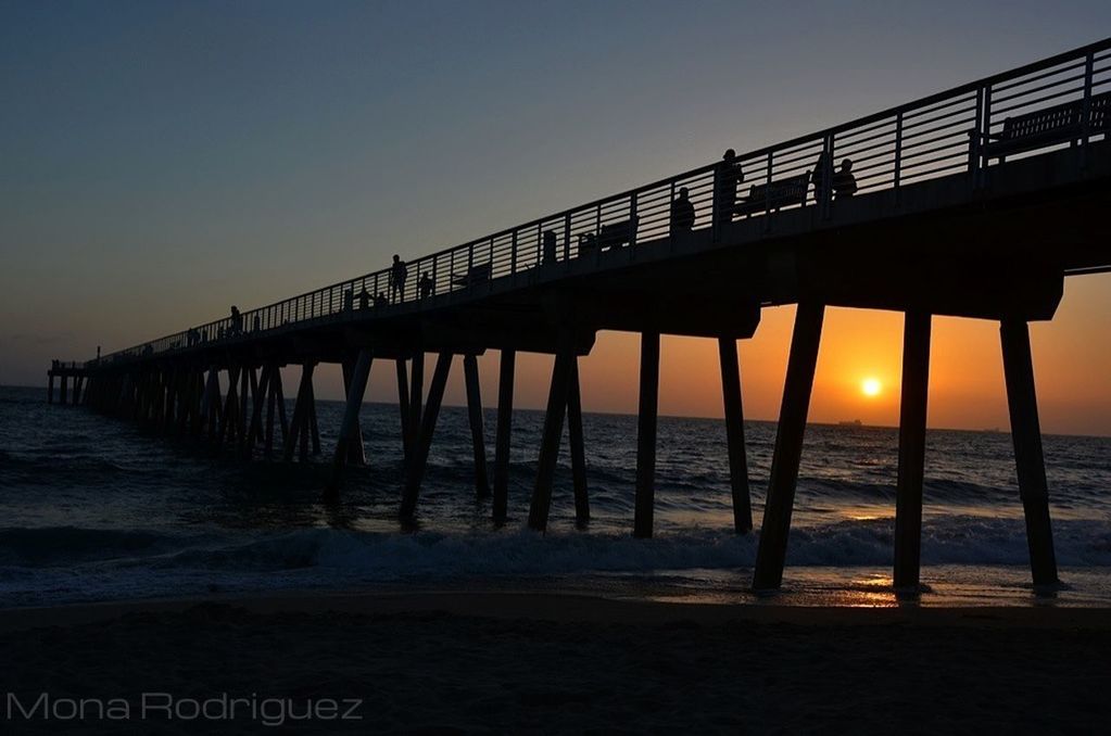 sea, water, sunset, pier, beach, horizon over water, tranquility, shore, built structure, scenics, tranquil scene, wooden post, sky, nature, beauty in nature, silhouette, wood - material, idyllic, wave, architecture