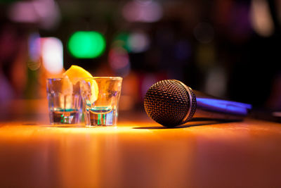 Close-up of drinks with microphone on wooden table