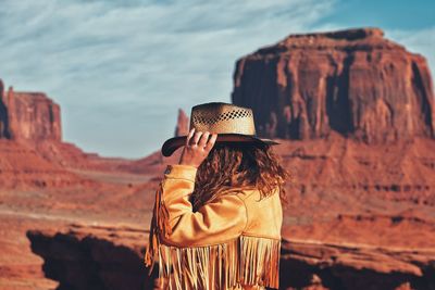 Rear view of woman photographing rock formation