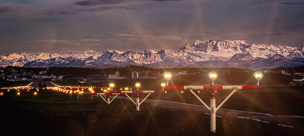 Illuminated lights on snowcapped mountains against sky at night