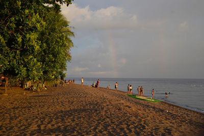 People at beach against sky