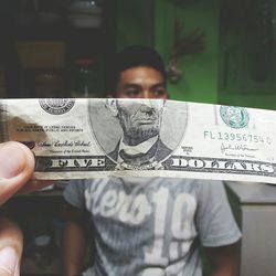 Close-up of paper currency against man in background