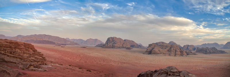 View of rock formations in desert against cloudy sky