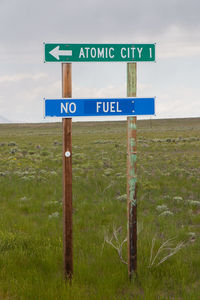 Information sign on field against sky