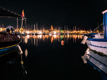 Boats moored in illuminated at night