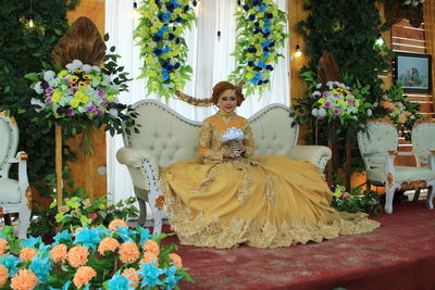 Woman holding flower bouquet against plants