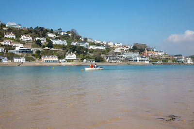 Scenic view of sea by town against sky