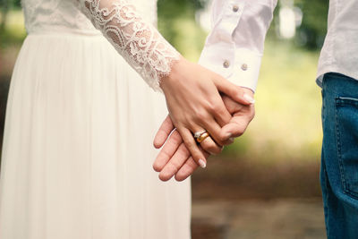 Midsection of couple holding hands