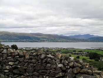 Scenic view of lake and mountains against cloudy sky