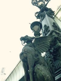 Low angle view of statue against building in city