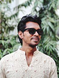 Young man wearing sunglasses looking away in park