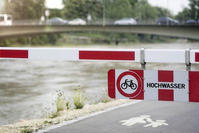 Road sign on street by river in city