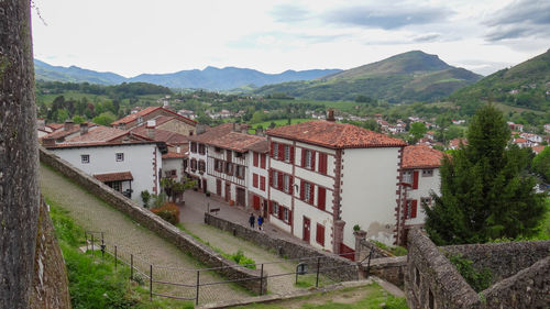 Houses by buildings against sky