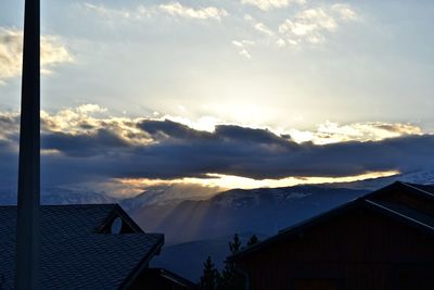 Houses and buildings against sky during sunset