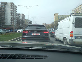 Cars on street in city against clear sky