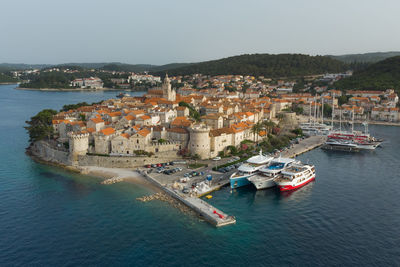 High angle view of townscape by sea against sky