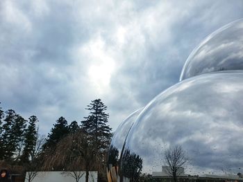 Low angle view of trees and building against sky