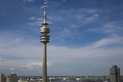 Communications tower against cloudy sky