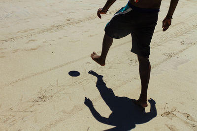 Low section of man playing on beach