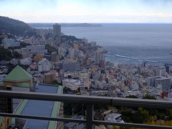 High angle view of city by sea against sky