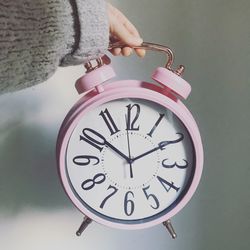 Cropped hand holding alarm clock