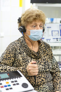 Audiologist checks the hearing of an older woman