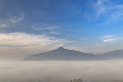 Scenic view of snowcapped mountains against cloudy sky