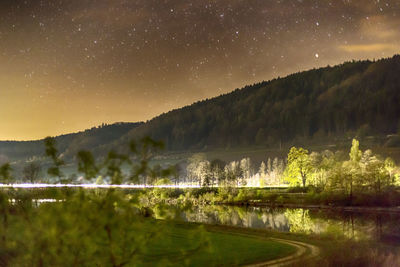 Scenic view of lake against sky at night