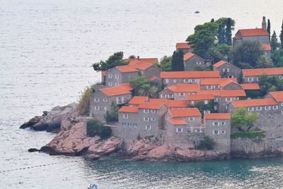 Houses by sea against buildings in city