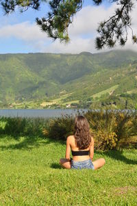 Woman sitting on grassy field