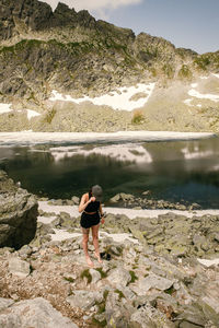 Man standing on rock at shore