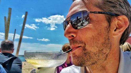 Close-up of man having drink on sunny day