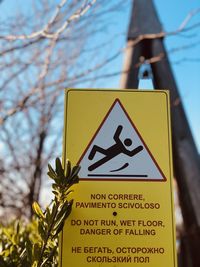 Close-up of yellow sign on tree